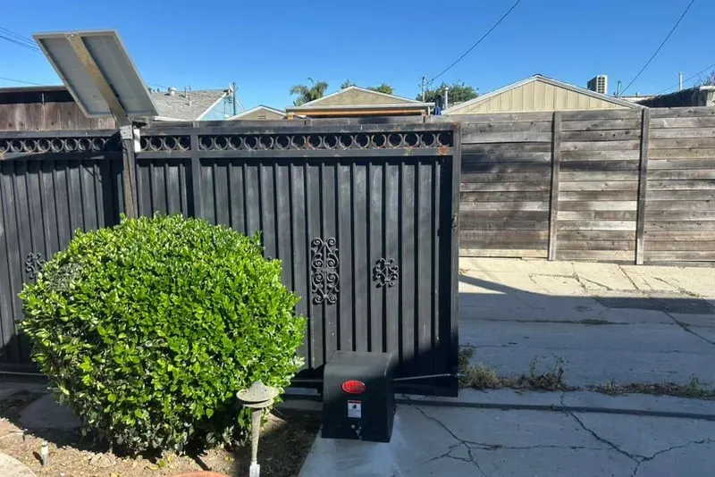 An All-O-Matic swing gate operator arm attached to a metal gate leaf