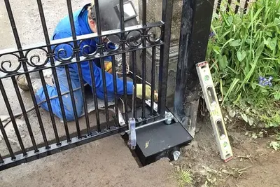 An Elite slide gate operator installed beside a residential driveway gate