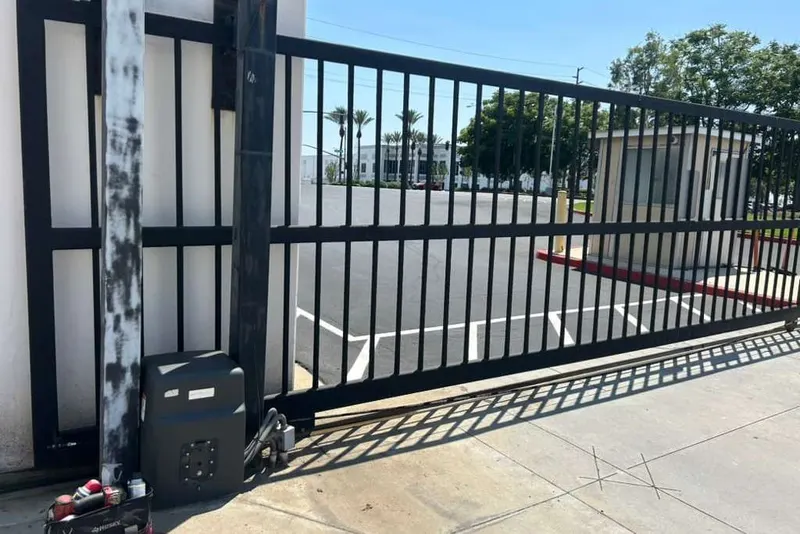 An Elite gate operator mounted on a concrete pad at a driveway entrance
