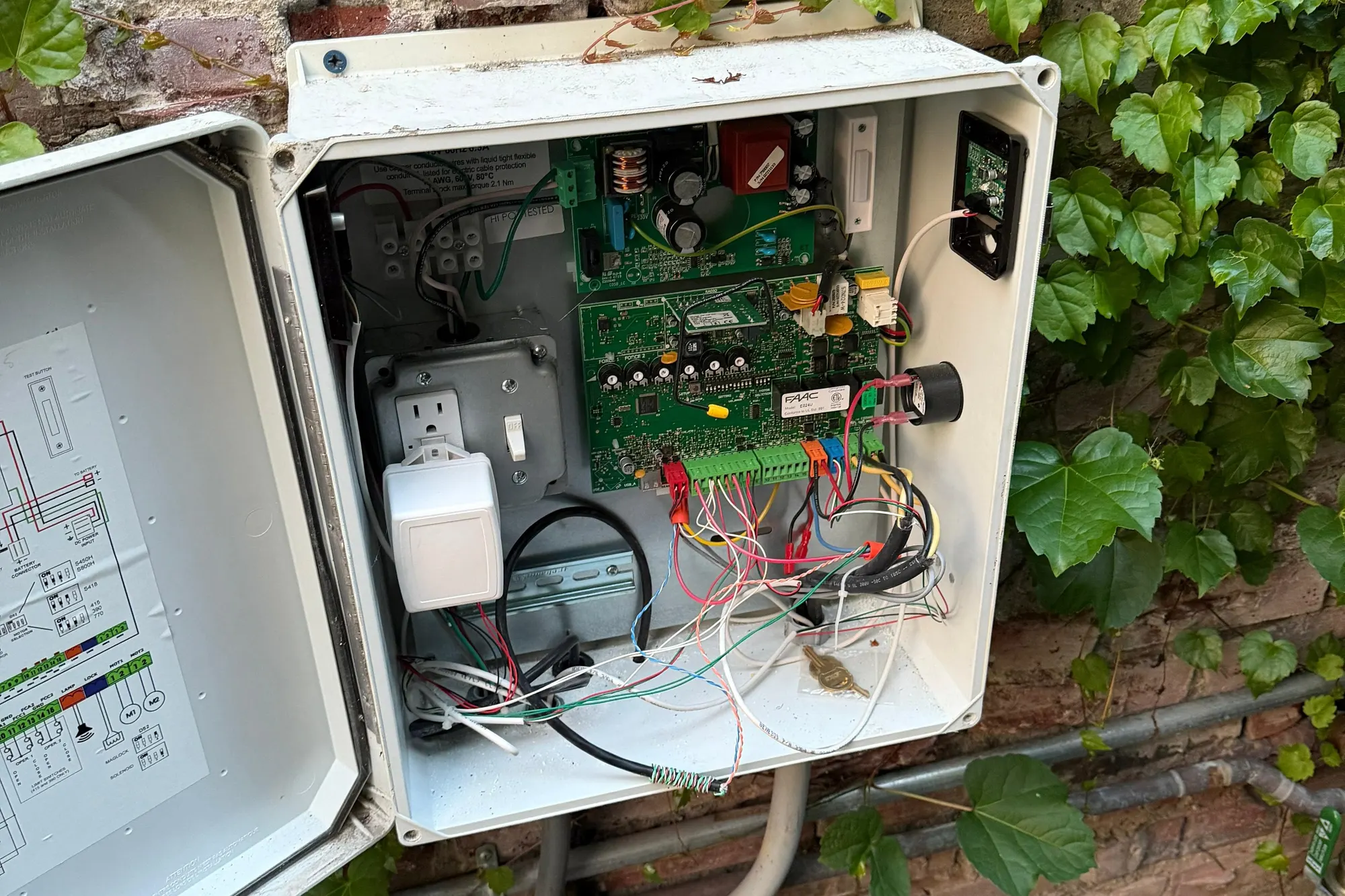 A FAAC hydraulic ram fitted to the leaf of a swing gate, viewed from the driveway side