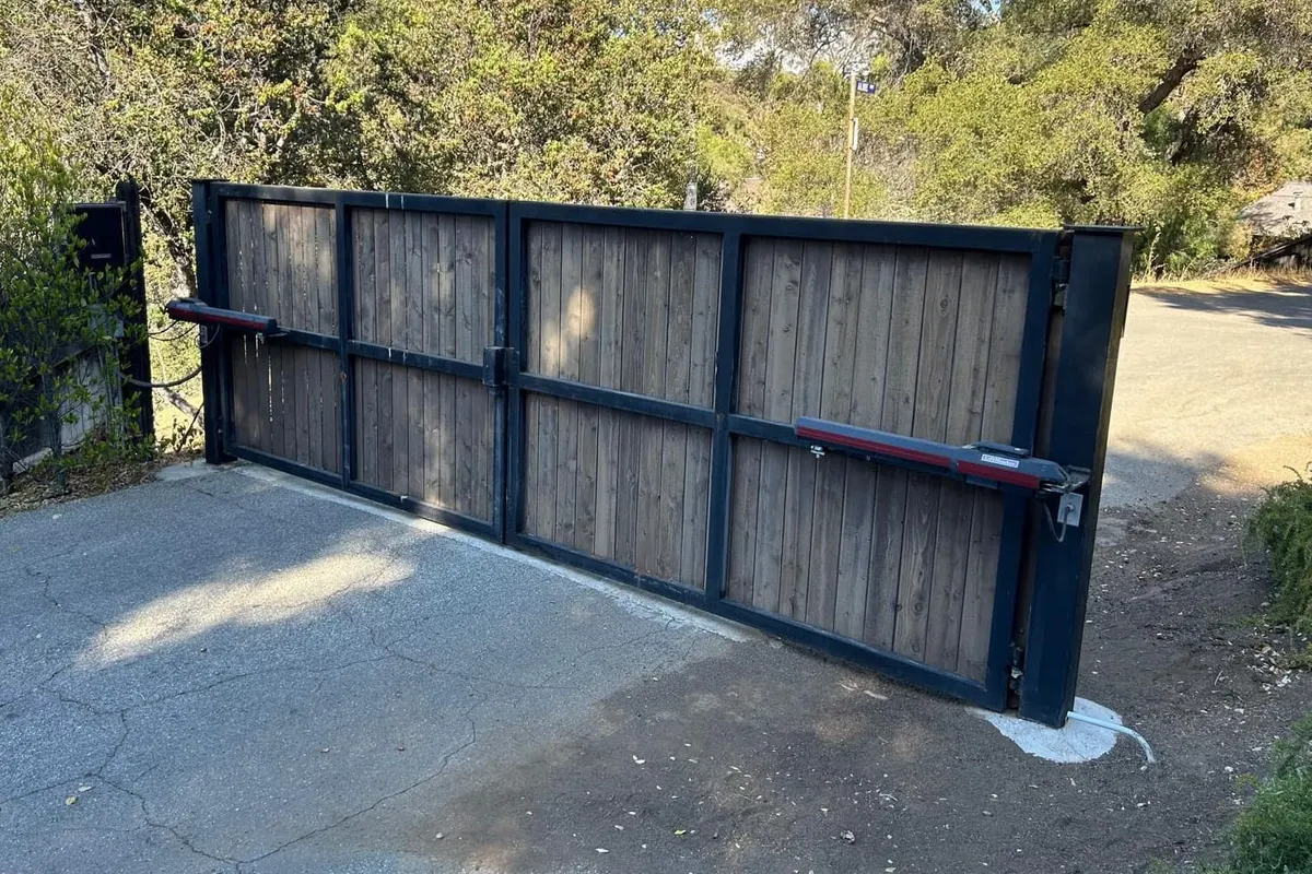 A keypad and call box mounted on a post at a new gate entrance