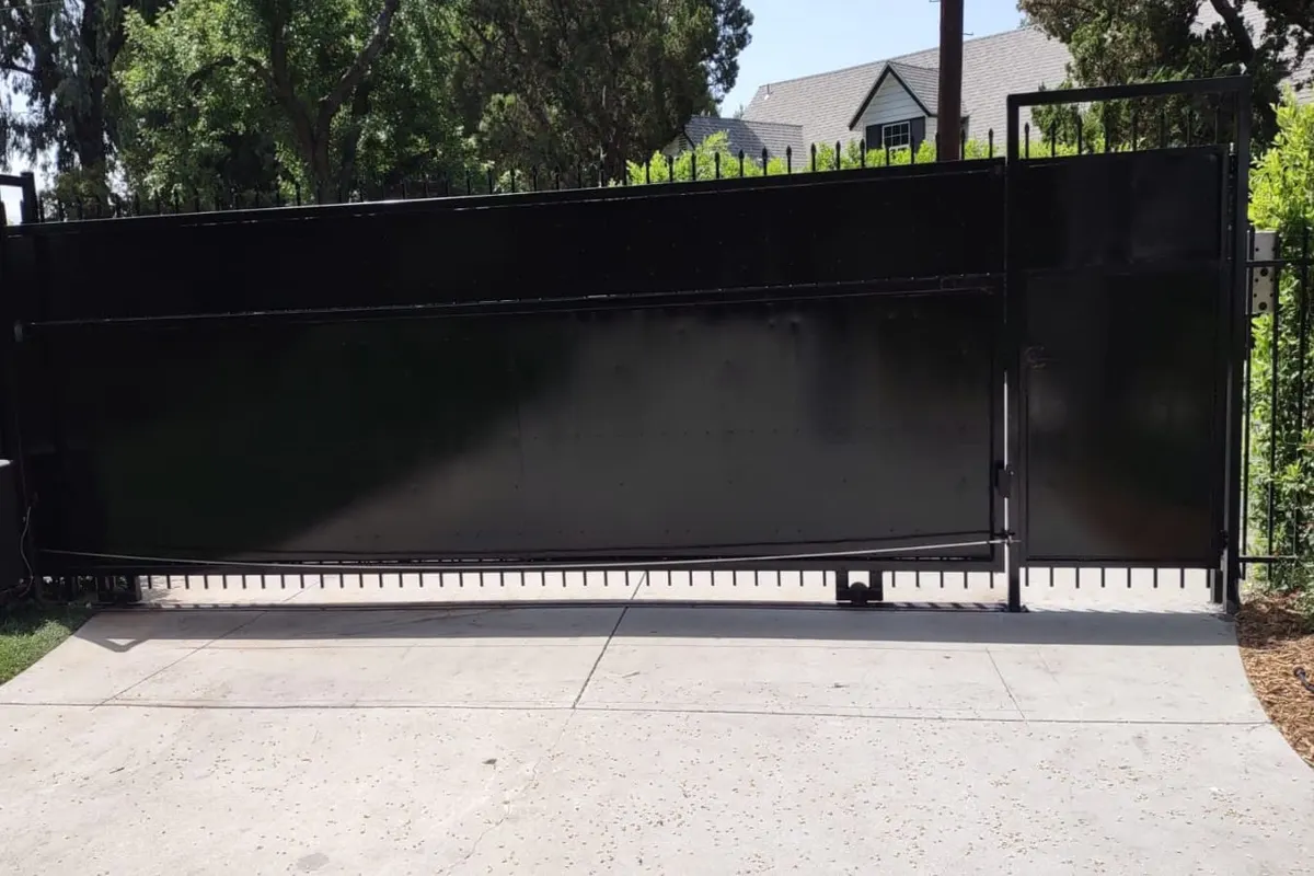 A straightened iron gate leaf rehung and closing square against its post
