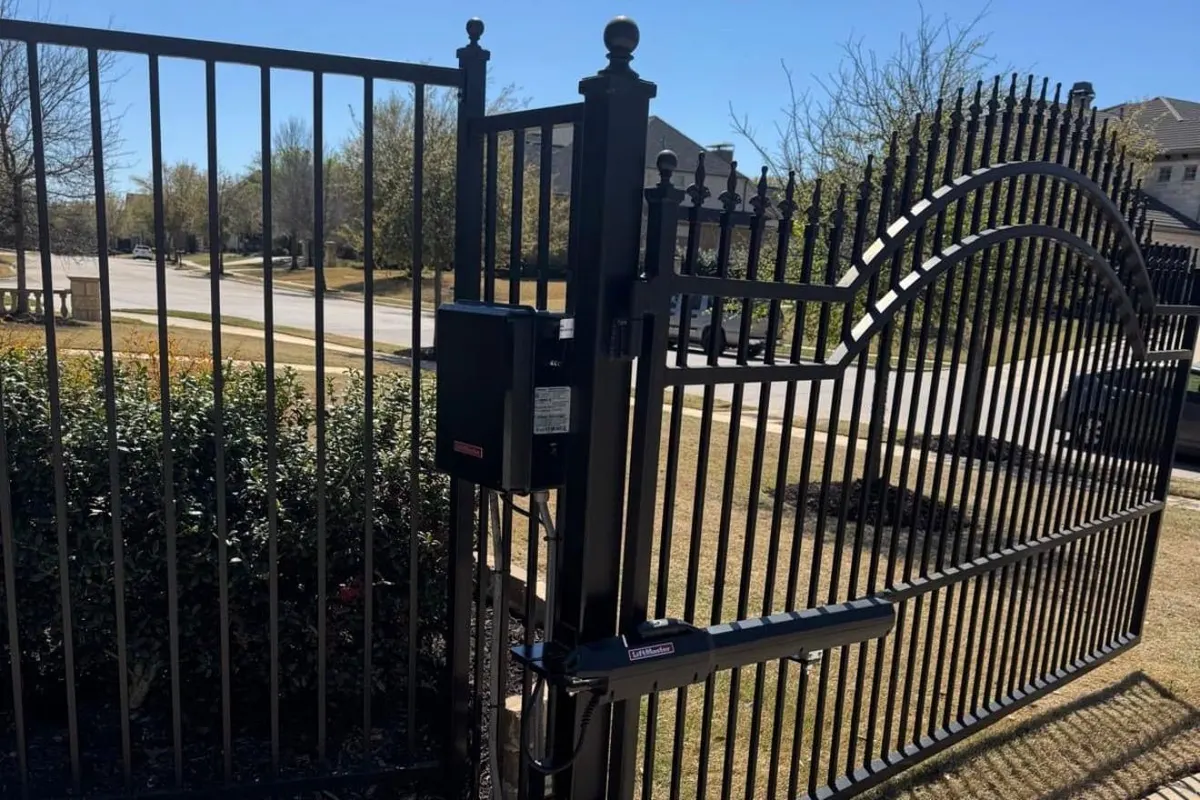 A LiftMaster operator installed on a concrete pad next to a sliding driveway gate